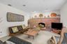Brick-faced fireplace with an arched opening, recessed lighting, and light-colored carpeting