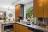 Wood-finish cabinetry paired with stone countertops and a stainless steel under-counter microwave