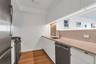Kitchen featuring white cabinetry, appliances with stainless steel finishes, decorative backsplash, light stone countertops, and modern cabinets