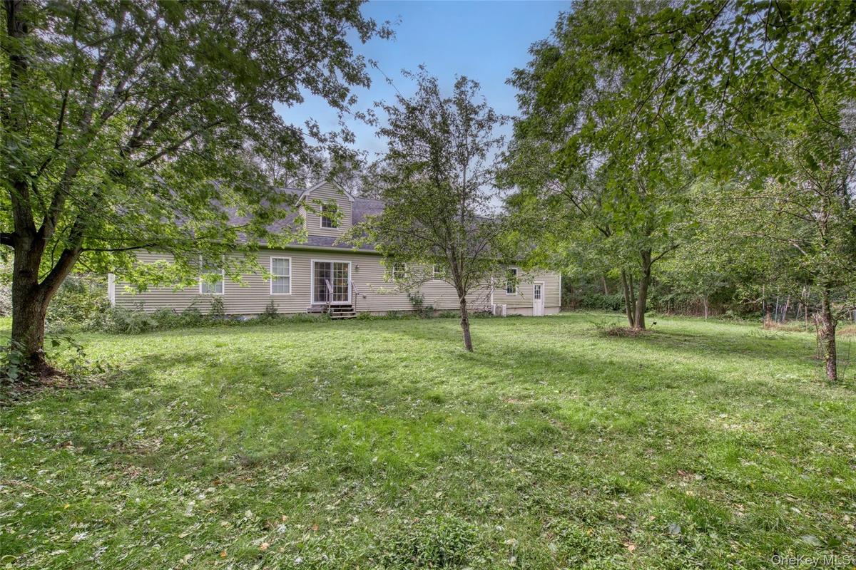 Expansive grassy yard with mature trees