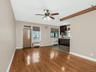 Unfurnished living room featuring baseboards, wood-type flooring, a ceiling fan, and radiator heating unit