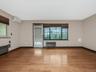 Empty room with an AC wall unit, light wood-style flooring, radiator, and baseboards