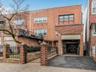 Multi unit property with aphalt driveway, an attached garage, fence, and brick siding