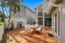 The private backyard is designed for effortless Florida living, featuring an expansive Spanish tile patio with a covered area for year-round enjoyment