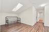The upstairs loft offers valuable flexibility as a children’s playroom, private home office, or intimate lounge. A skylight fills the space with natur
