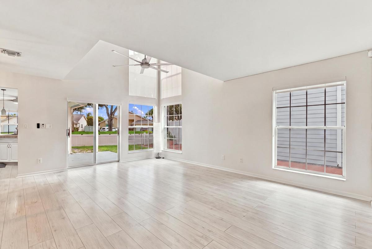 From the moment you enter, soaring ceilings and expansive windows fill the home with natural light, creating a bright, welcoming atmosphere that immed