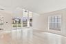 From the moment you enter, soaring ceilings and expansive windows fill the home with natural light, creating a bright, welcoming atmosphere that immed