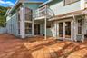 The private backyard is designed for effortless Florida living, featuring an expansive Spanish tile patio with a covered area for year-round enjoyment
