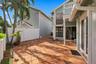 The private backyard is designed for effortless Florida living, featuring an expansive Spanish tile patio with a covered area for year-round enjoyment