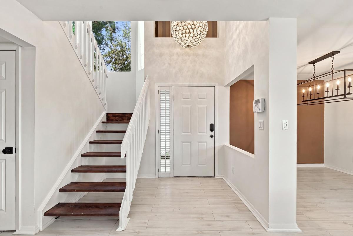 From the moment you enter, soaring ceilings and expansive windows fill the home with natural light, creating a bright, welcoming atmosphere that immed