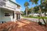 The private backyard is designed for effortless Florida living, featuring an expansive Spanish tile patio with a covered area for year-round enjoyment