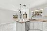 The bright eat-in kitchen features contemporary white cabinetry, granite countertops, new stainless steel appliances, and a convenient breakfast bar. 