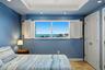 Bright guest bedroom with a peaceful coastal outlook.