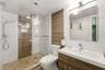 Contemporary bath featuring floor-to-ceiling tile and modern finishes.