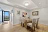 Light-filled dining area with elegant tray ceiling and recessed lighting.