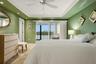 Spacious primary bedroom with coastal views and natural light