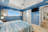 Comfortable guest bedroom with ample natural light and Gulf view.