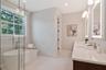 Dual vanities, glass shower, and tub in primary bath