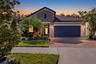 Twilight view with extended paver driveway and landscape lighting
