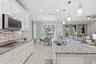 Gourmet kitchen anchored by a large island with seating for three and glass French doors leading to the patio