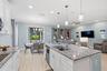 Living room and kitchen flow together, with French doors open to the lanai