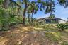 Backyard fenced on both sides, with mature tree cover