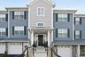 Townhome exterior featuring varied siding materials, stone accents, and a covered entry porch