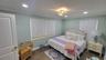 Recessed lighting, crown molding, two windows with blinds, wood-finish flooring, and a decorative ceiling fixture