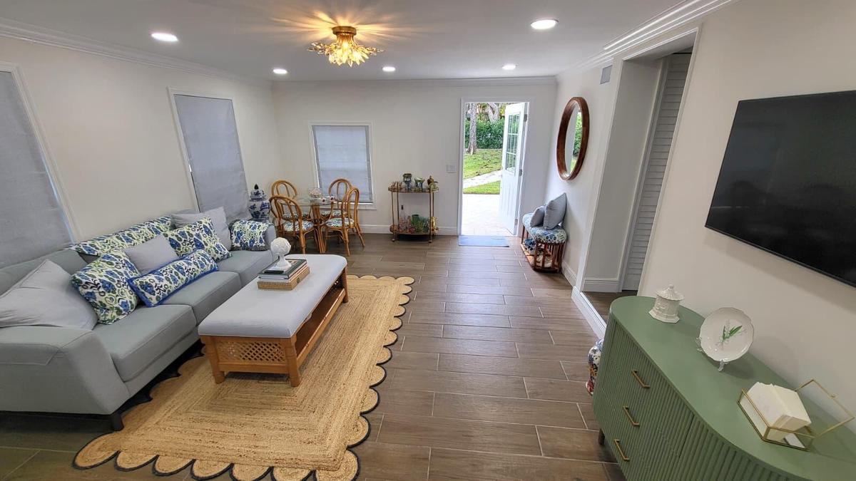 Open-concept living area featuring wood-finish tile flooring, recessed lighting, and a decorative ceiling fixture