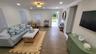 Open-concept living area featuring wood-finish tile flooring, recessed lighting, and a decorative ceiling fixture