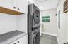 Oversized laundry room with Shaker cabinetry, quartz countertops (all match kitchen), utility sink, storage and FULL size stackable LG ThinQ high effi