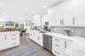 White Shaker cabinetry with upper and lower molding details and under counter lighting.