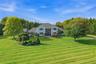 Expansive green lawn with mature trees and landscaped planting beds