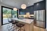 Kitchen featuring a large center island with a light-toned countertop, dark blue cabinetry, stainless steel French door refrigerator, and a gas range