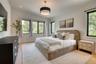 Recessed lighting, wood-finish flooring, white walls, black-framed windows, and a semi-flush mount ceiling light