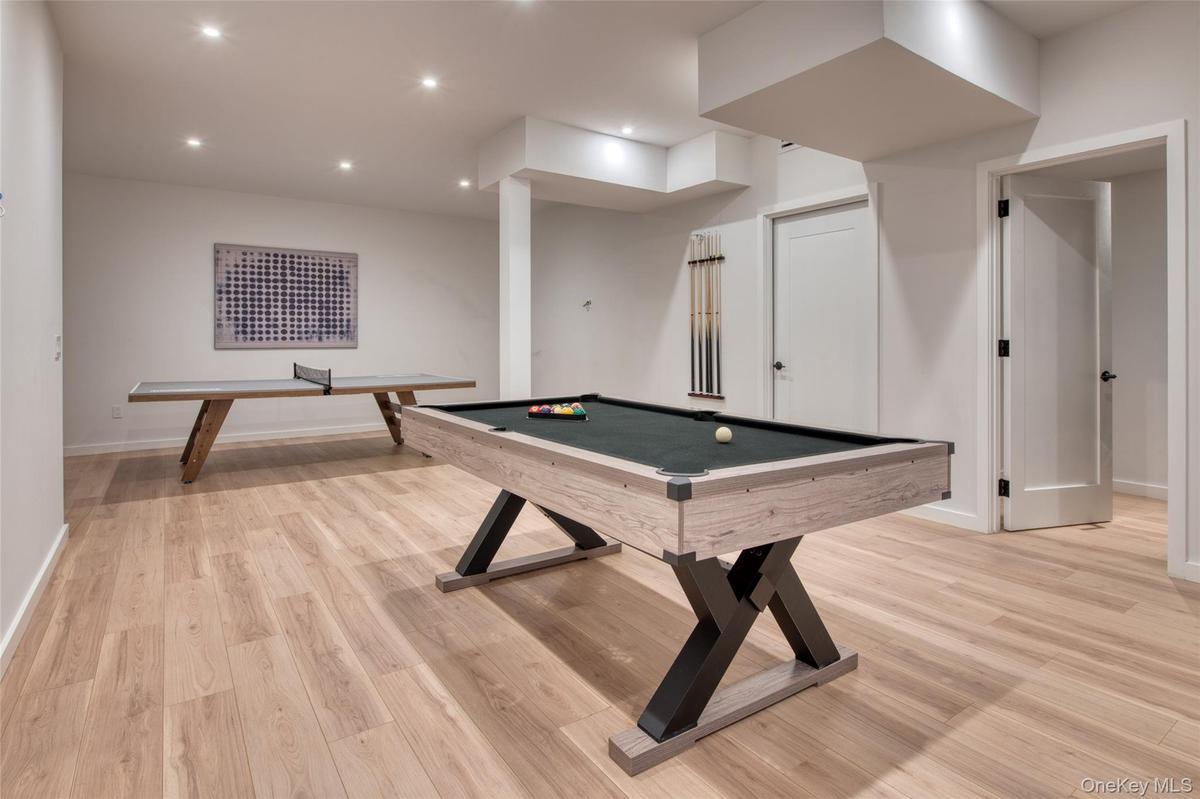 Recessed lighting, light wood-finish flooring, white walls, and multiple panel doors
