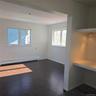 Unfurnished room featuring baseboard heating and dark hardwood / wood-style floors