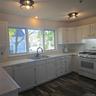 Kitchen with white cabinetry, extractor fan, dark hardwood / wood-style floors, sink, and white appliances