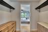Walk-in closet featuring light wood-finish flooring