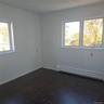 Unfurnished room with baseboard heating, a wealth of natural light, and dark parquet flooring