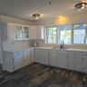 Kitchen with white cabinetry, sink, and dishwasher