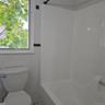 Bathroom with toilet and tile walls