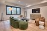 Recessed lighting, wood-finish flooring, and a window with black trim