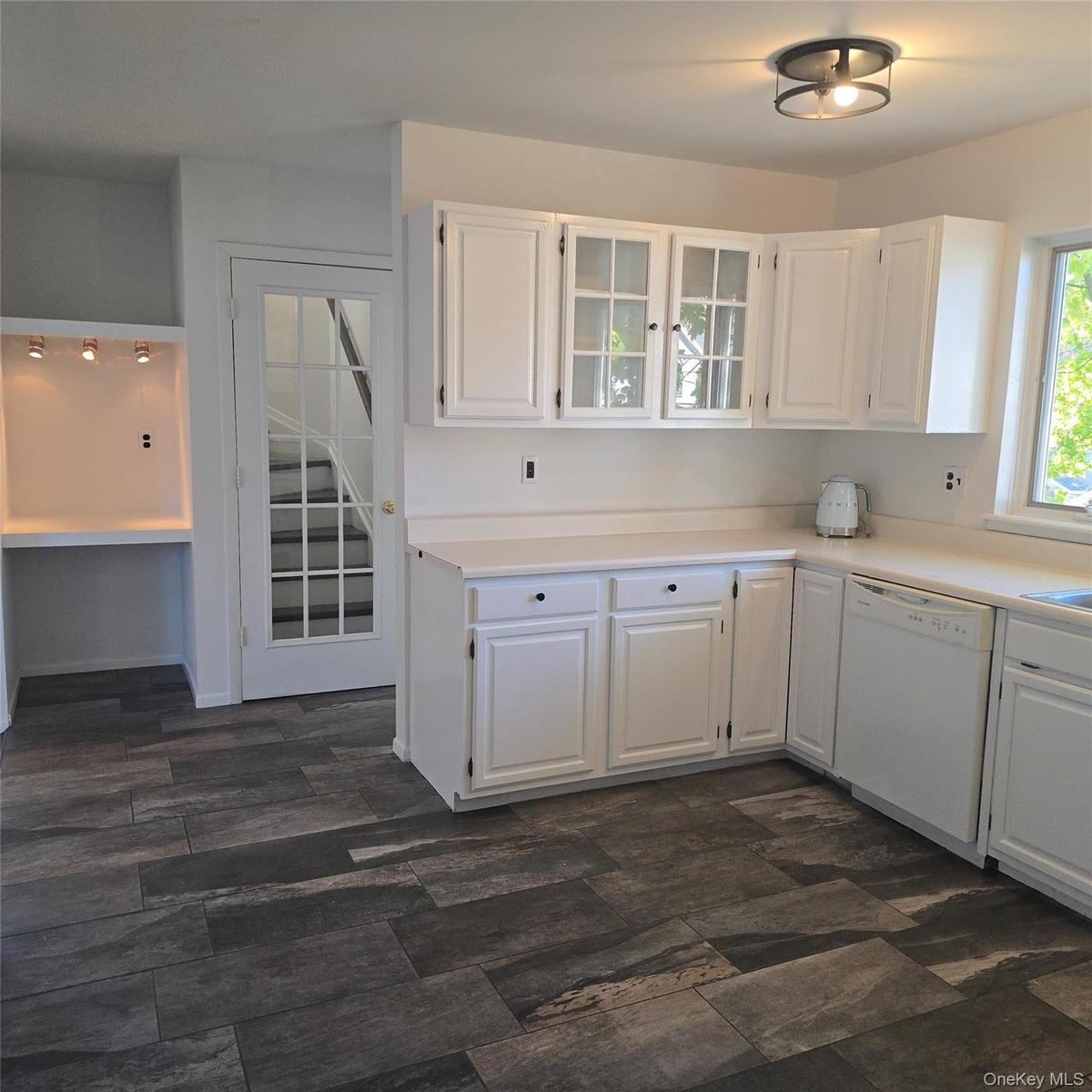 Kitchen with dishwasher, dark hardwood / wood-style flooring, and white cabinetry