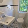 Bathroom featuring sink, tile walls, and toilet