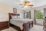 Wall-to-wall carpeting, two large windows, and a ceiling fan with integrated lighting
