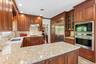 Kitchen featuring wood cabinetry, light-toned countertops, stainless steel appliances, and recessed lighting