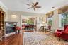 Hardwood flooring, decorative fireplace, crown molding, and a ceiling fan with integrated lighting