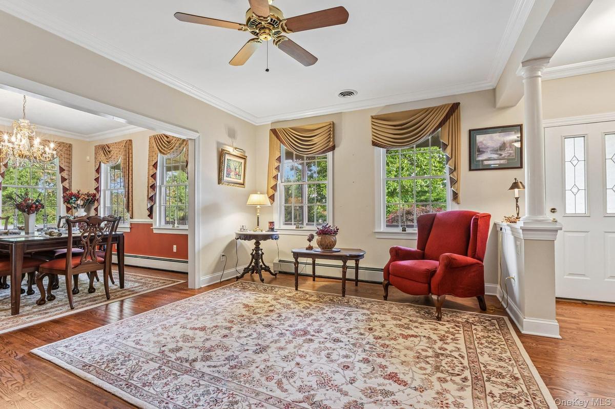 Wood-finish flooring, crown molding, and a ceiling fan with integrated lighting