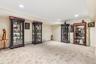 Recessed lighting, crown molding, and neutral wall tones complement the neutral carpeting